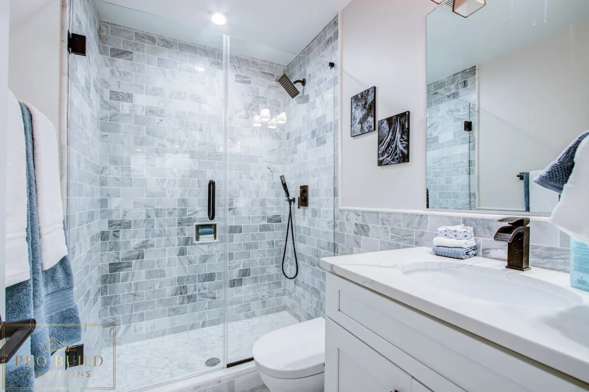 Classic bathroom renovation featuring a frameless glass shower, white cabinet vanity, and gray marble tile surround, Wood Dale