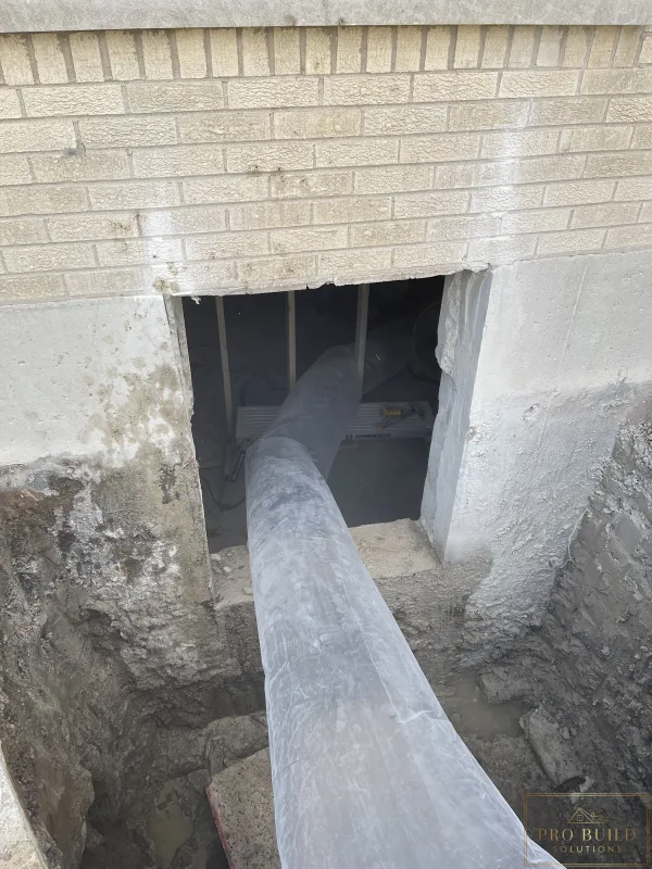 Egress window area trenched to the bottom of the foundation for proper drainage, creating proper ventilation in place while cutting the 24"w * 48"h opening for the window., Elmhurst