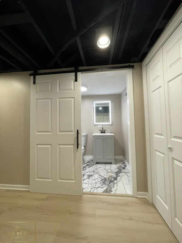Entrance View of Basement Bathroom. Barn Door with Black Finishes, Itasca, IL