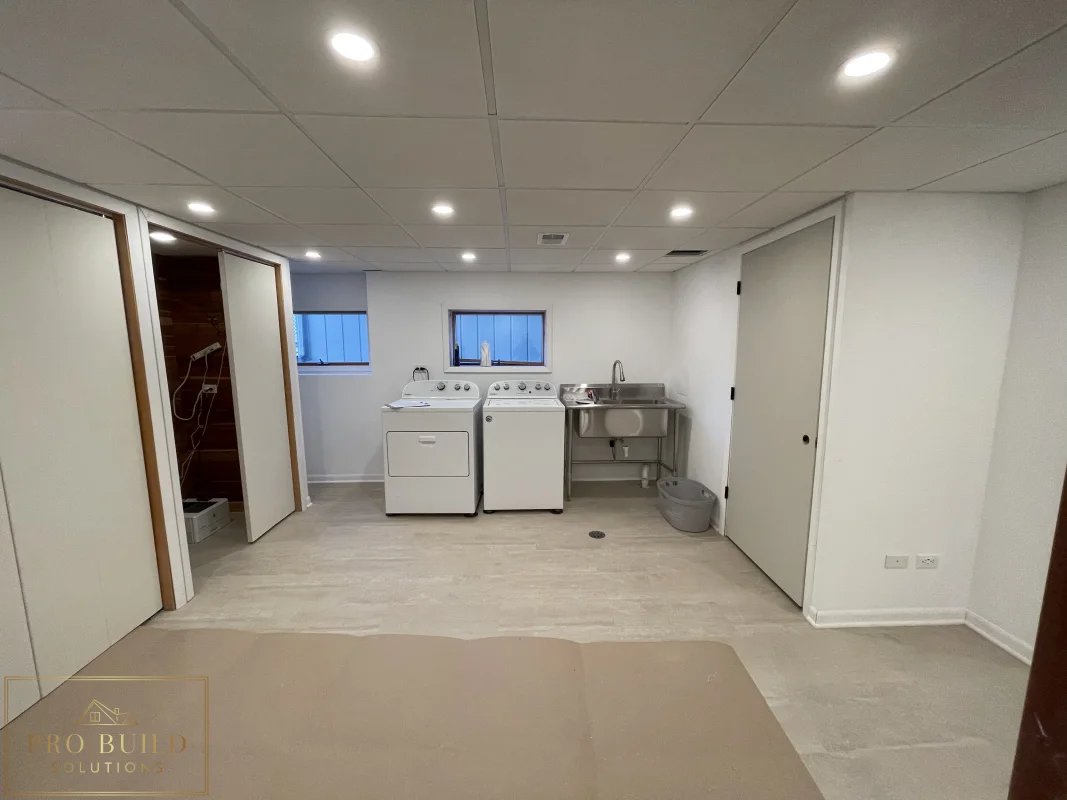 Basement finishing project with laundry space, recessed ceiling lights, closet doors, and durable plank flooring, Western Springs