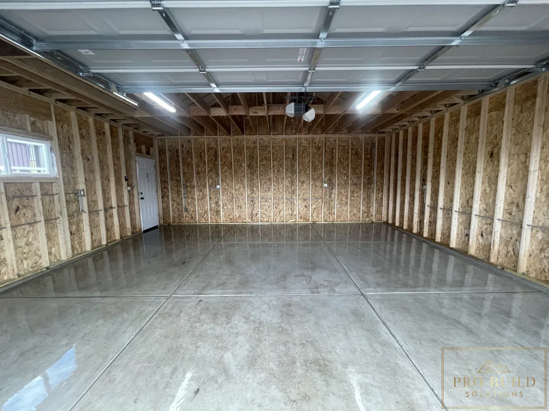 Finished garage interior with concrete floor, framing, and overhead lighting, Wood Dale, IL