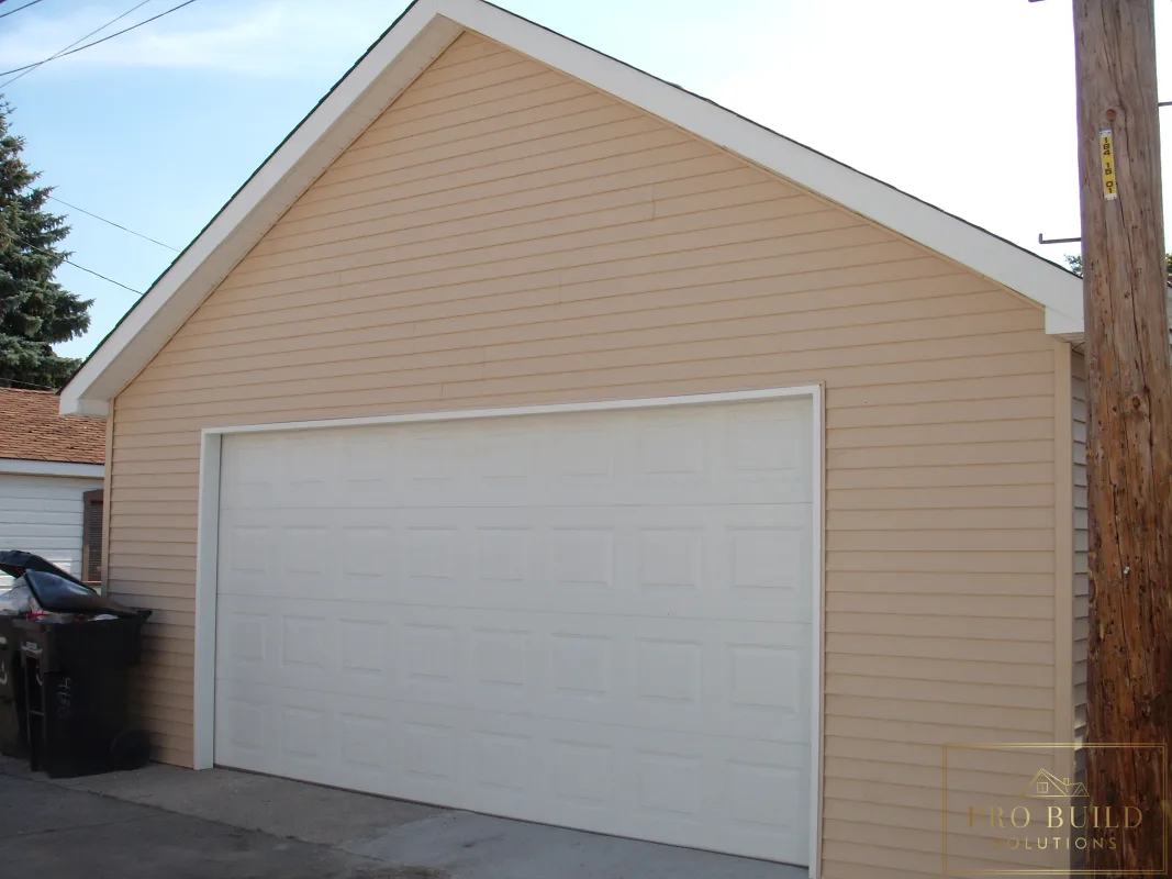 Exterior garage renovation with beige siding, white overhead door, and low-maintenance finishes, Chicago, IL
