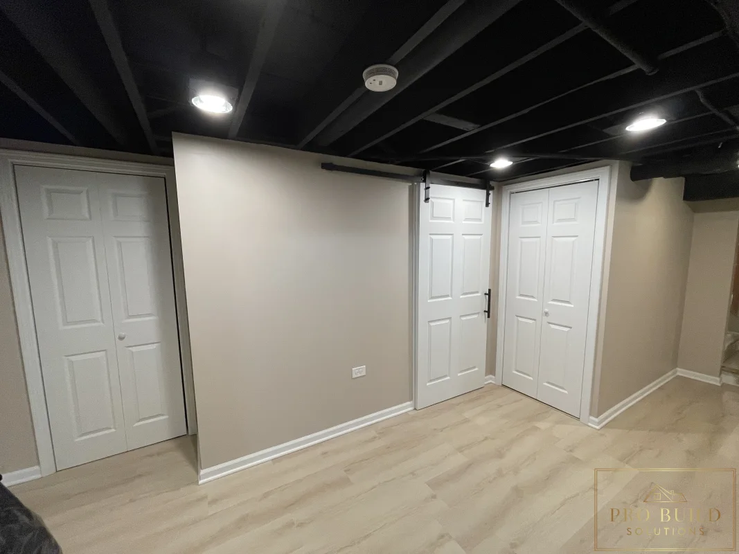 Finished basement interior with light flooring, black ceiling detail, and clean modern basement finishes, Glen Ellyn
