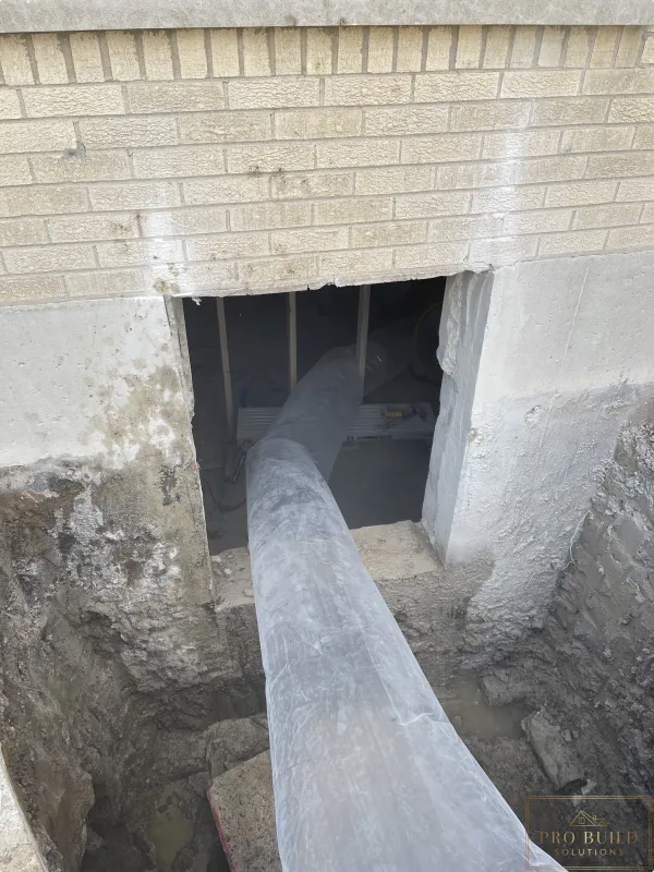 Egress window area trenched to the bottom of the foundation for proper drainage, creating proper ventilation in place while cutting the 24"w * 48"h opening for the window., Elmhurst