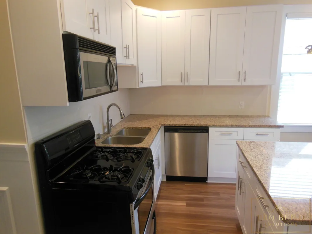 Updated kitchen remodel featuring white cabinets, gas range, built-in microwave, and wood-look flooring, Lombard
