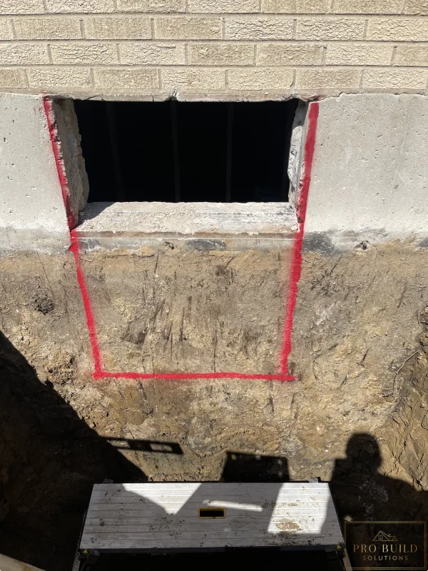 Egress window area trenched to the bottom of the foundation for proper drainage, while tracing the 24"w * 48"h opening for the window., Elmhurst