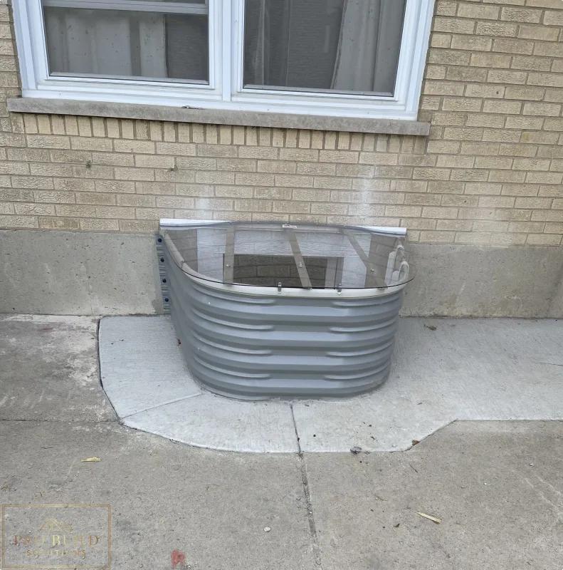 Basement window well upgrade featuring corrugated metal well, clear cover, and masonry wall detail, Elmhurst