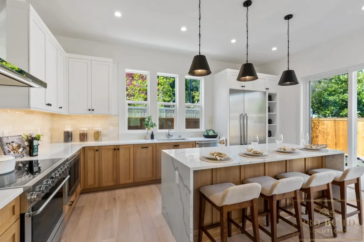 Open-concept kitchen with mixed white and natural wood cabinetry, quartz island seating, and tall windows for natural light, Hinsdale, IL