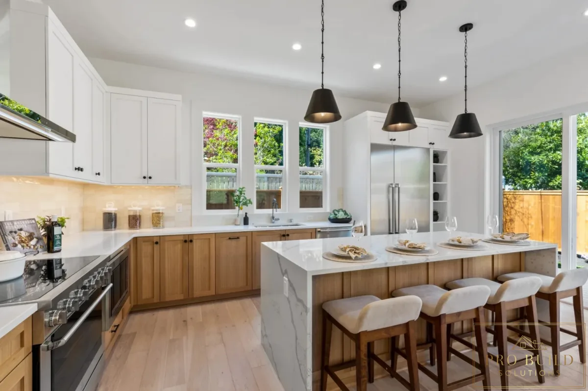 Open-concept kitchen with mixed white and natural wood cabinetry, quartz island seating, and tall windows for natural light, Hinsdale, IL
