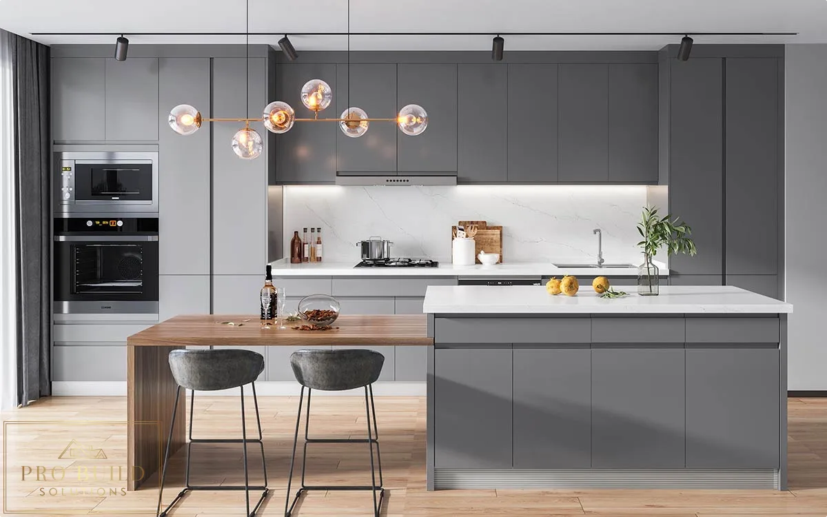 Sleek gray modern kitchen featuring handleless-style cabinets, waterfall island, built-in ovens, and contemporary globe chandelier, Lisle