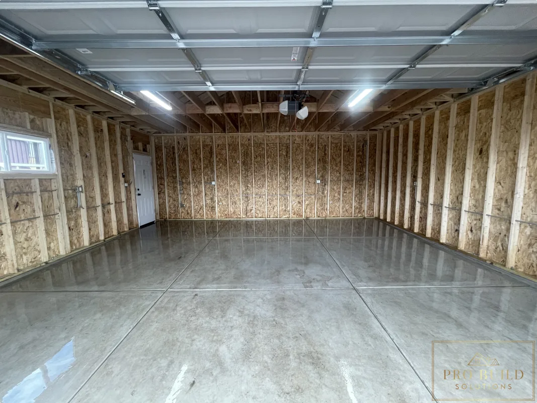 Finished garage interior with concrete floor, framing, and overhead lighting, Wood Dale, IL
