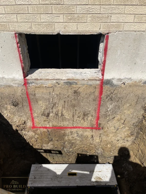 Egress window area trenched to the bottom of the foundation for proper drainage, while tracing the 24"w * 48"h opening for the window., Elmhurst