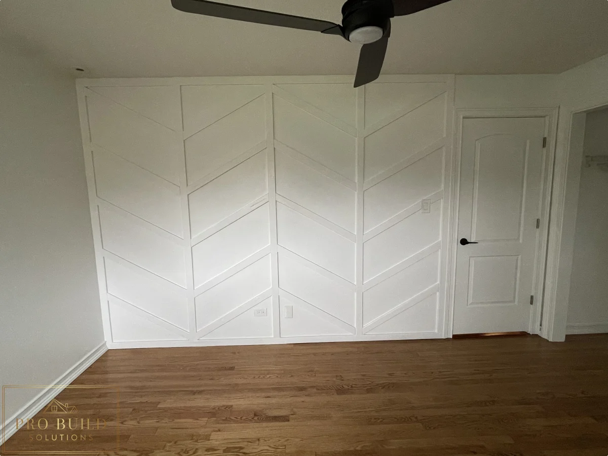 Finished bedroom interior with custom white feature wall, ceiling fan, and classic trim details, Wheaton