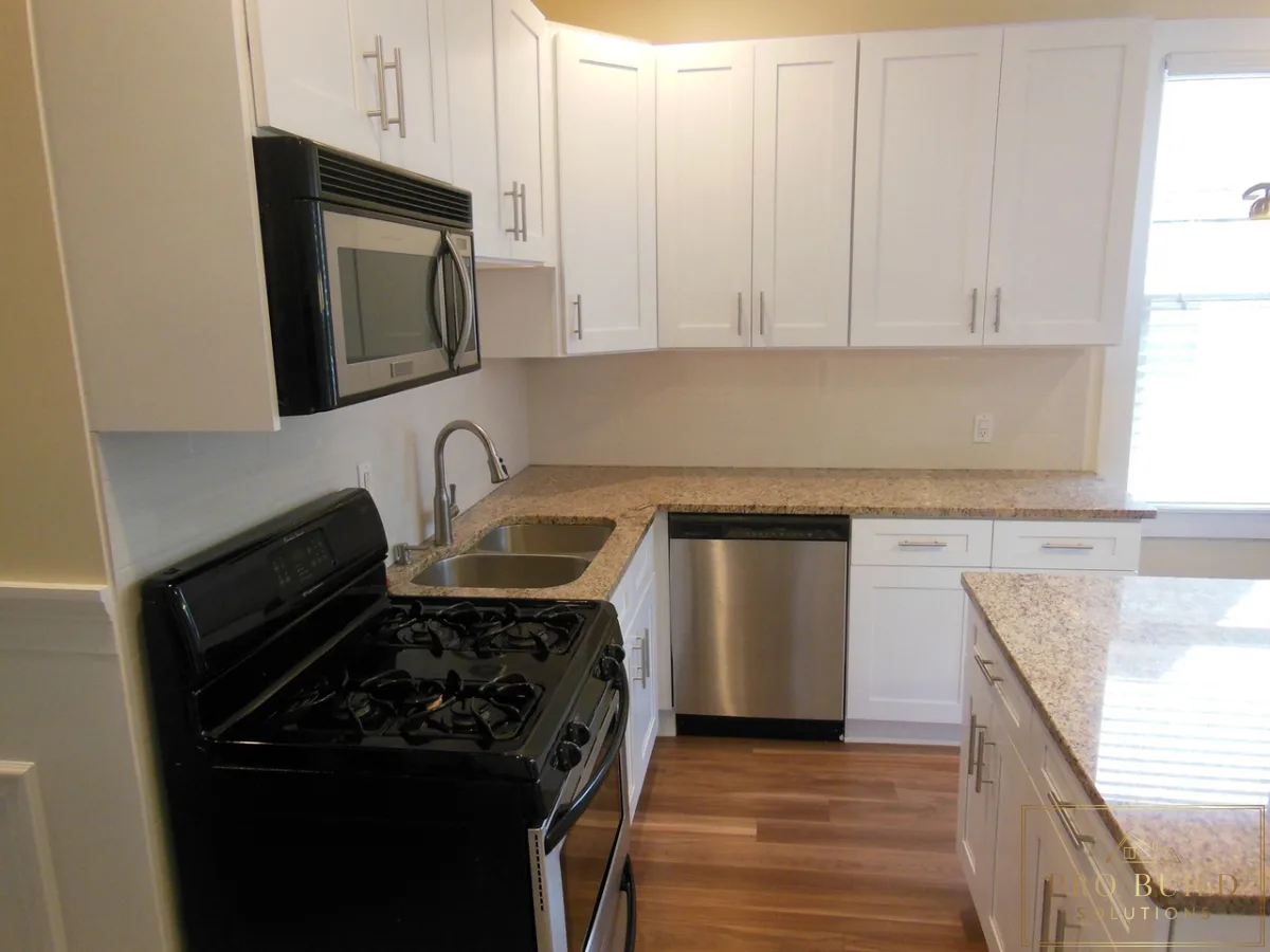 Custom kitchen renovation with bright white cabinets, granite counters, and improved storage layout, Lombard, IL