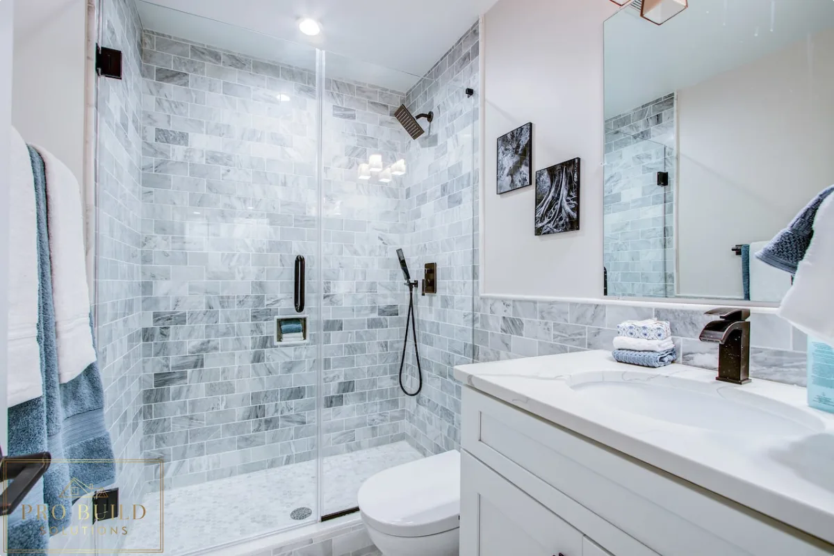 Classic bathroom renovation featuring a frameless glass shower, white cabinet vanity, and gray marble tile surround, Wood Dale