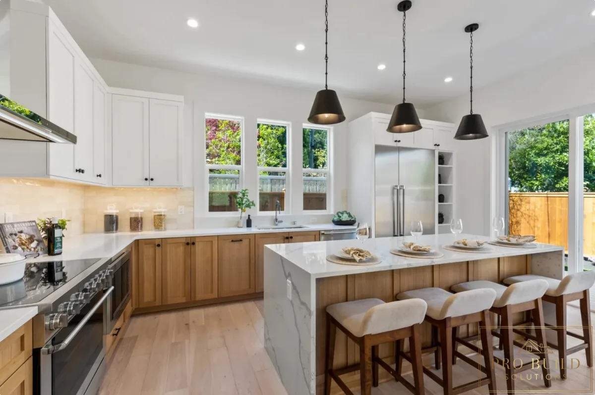 Open-concept kitchen with mixed white and natural wood cabinetry, quartz island seating, and tall windows for natural light, Hinsdale, IL