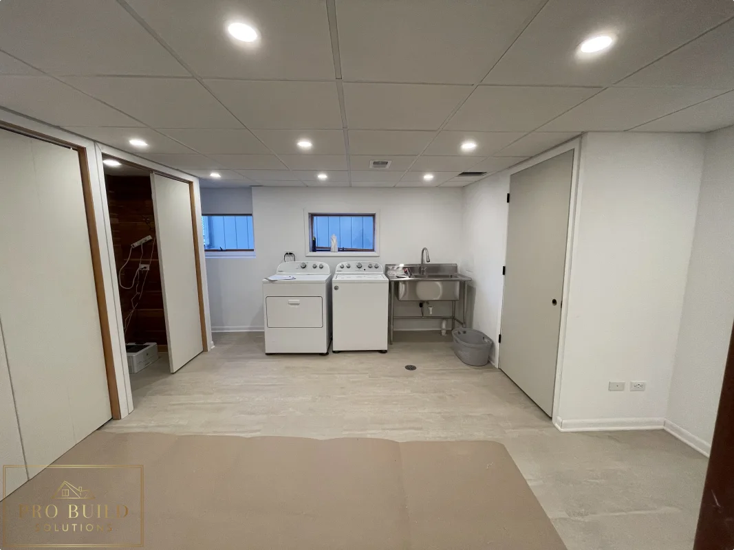 Basement finishing project with laundry space, recessed ceiling lights, closet doors, and durable plank flooring, Western Springs