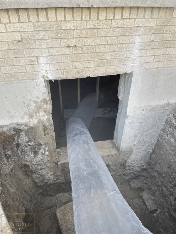 Egress window area trenched to the bottom of the foundation for proper drainage, creating proper ventilation in place while cutting the 24"w * 48"h opening for the window., Elmhurst