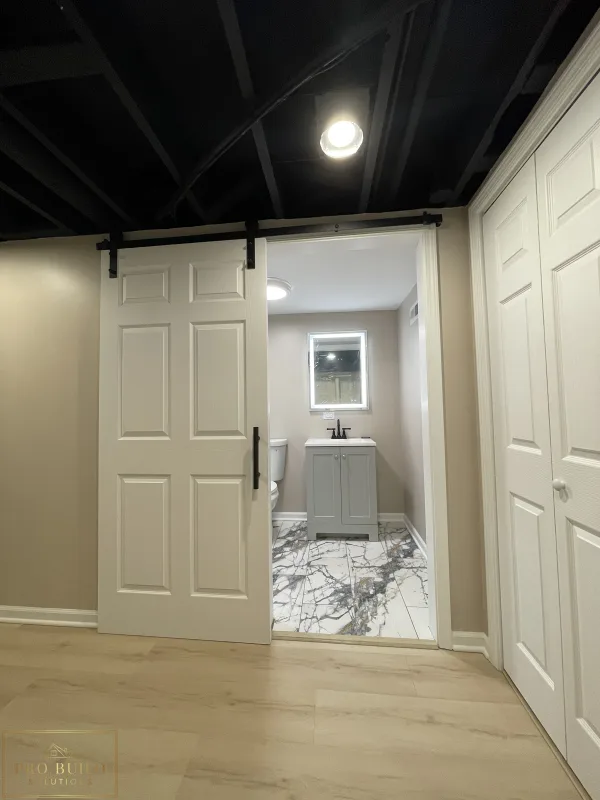 Entrance View of Basement Bathroom. Barn Door with Black Finishes, Itasca, IL