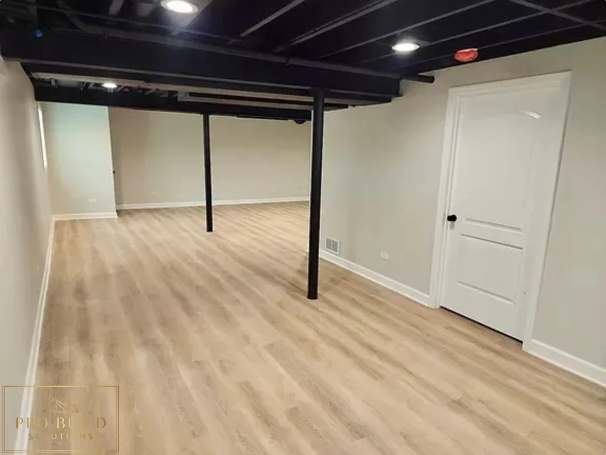 Basement remodel with exposed ceiling design, light flooring, and spacious open recreation area, St. Charles