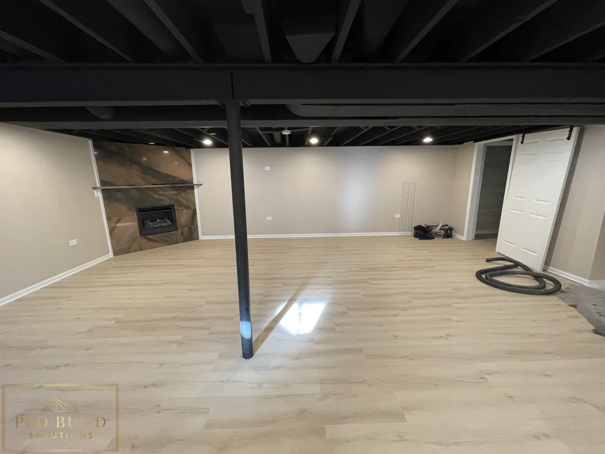 Basement remodel with fireplace accent wall, durable plank flooring, and modern exposed ceiling design, Naperville