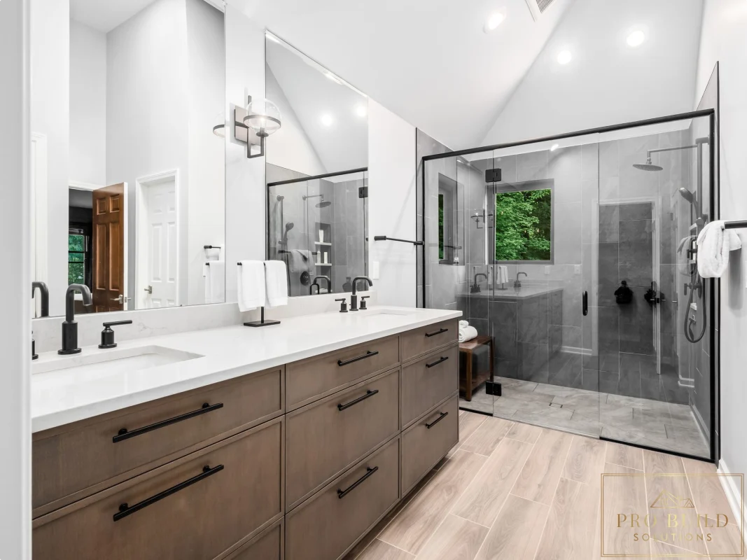 Transitional primary bathroom remodel with double wood vanity, oversized glass shower, and light wood-look tile flooring, Oakbrook