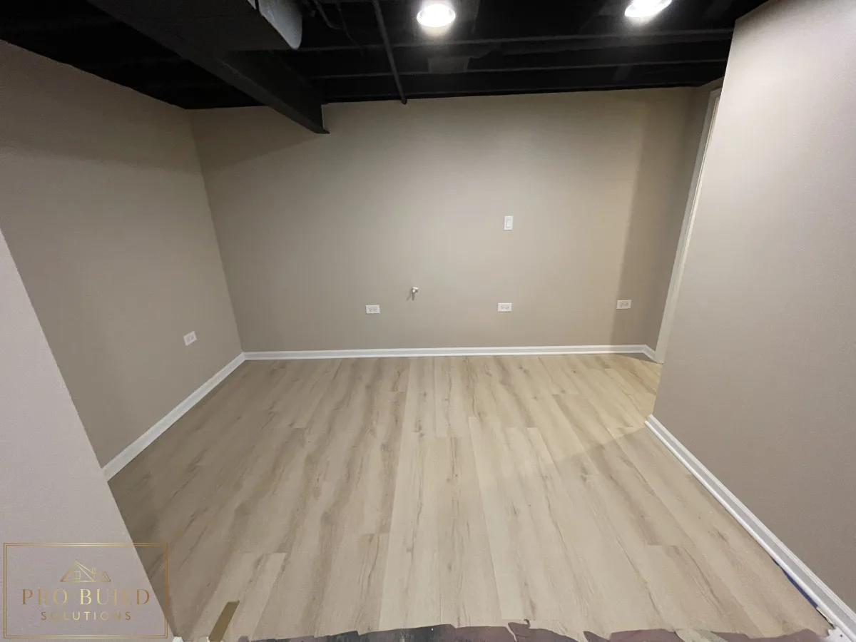 Finished basement bonus room with modern flooring, black exposed ceiling, and electrical wall outlets, Crest Hill