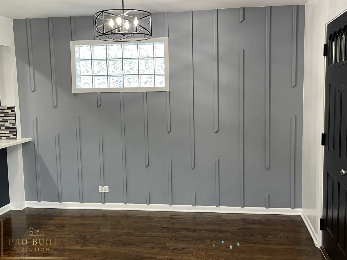 Finished interior space with custom gray accent wall, black door, white trim, and polished hardwood flooring, Western Springs, IL