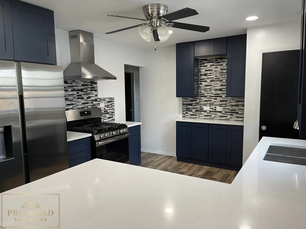 Residential kitchen renovation with navy cabinetry, quartz counters, wood-look flooring, and updated appliances, La Grange, IL