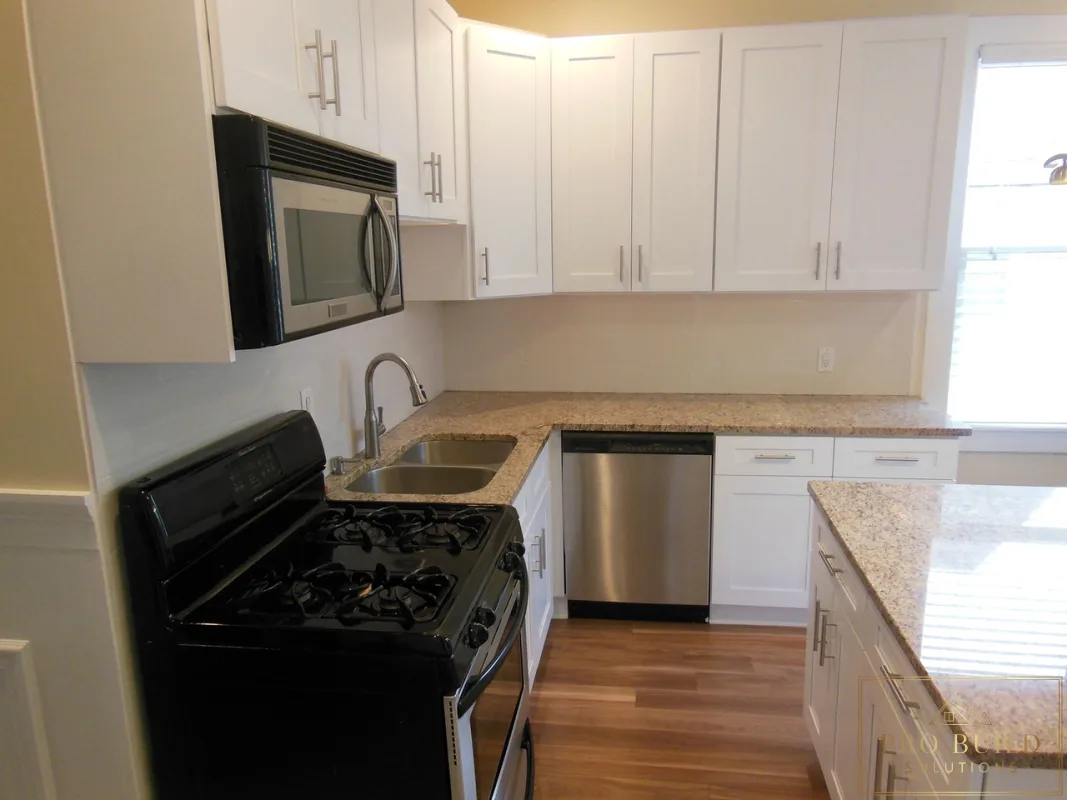 Updated kitchen remodel featuring white cabinets, gas range, built-in microwave, and wood-look flooring, Lombard