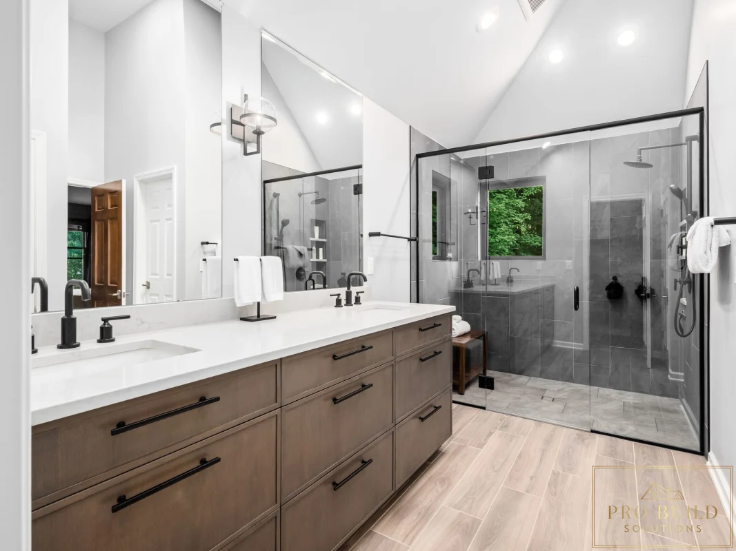 Transitional primary bathroom remodel with double wood vanity, oversized glass shower, and light wood-look tile flooring, Oakbrook